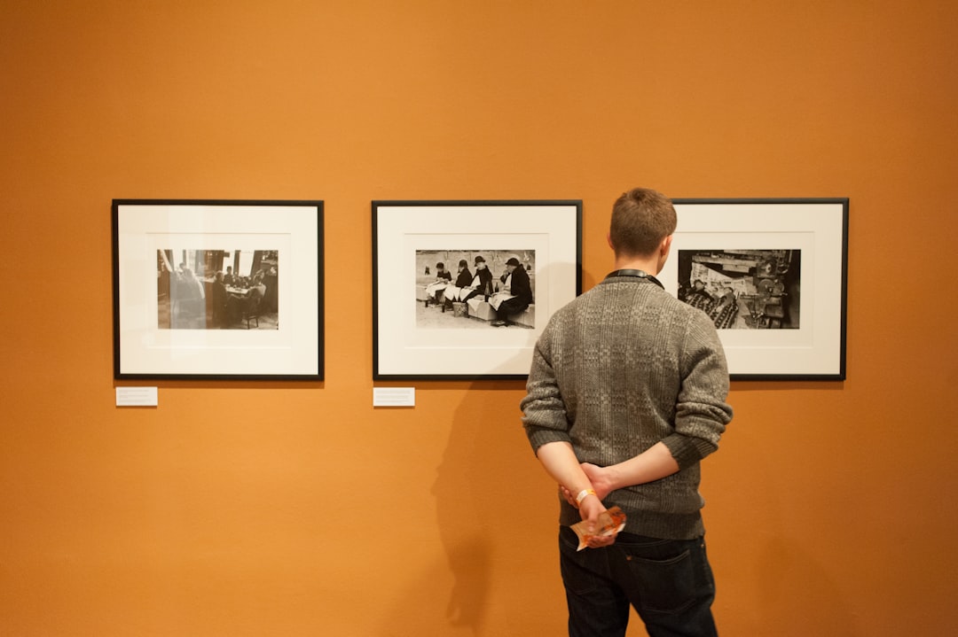 man in gray sweater standing near wall